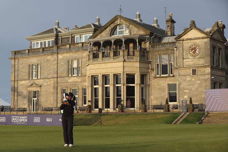 Lydia Ko, of New Zealand, kisses the trophy in front of the Club house after winning the Women's British Open golf championship, and becoming Champion golfer , in St. Andrews, Scotland, Sunday, Aug. 25, 2024. (AP Photo/Scott Heppell)