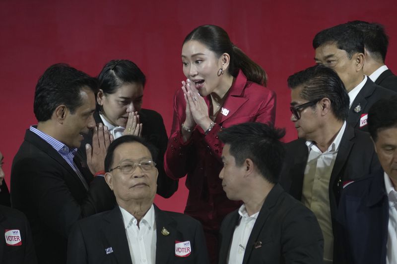 FILE- New leader of Pheu Thai Party, Paetongtarn Shinawatra, center, daughter of Thailand's former Prime Minister Thaksin Shinawatra, offers a traditional greeting known as a "wai" to member of Pheu Thai Party at the party headquarters in Bangkok, Thailand, Friday, Oct. 27, 2023. (AP Photo/Sakchai Lalit, File)