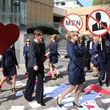 Kirsha Kaechele, curator of a ladies' lounge at Tasmania's Museum of Old and New Art, back center, and supporters dance outside the Supreme Court of Tasmania in Hobart, Australia, Friday, Sept. 27, 2024. (Ethan James/AAP Image via AP)