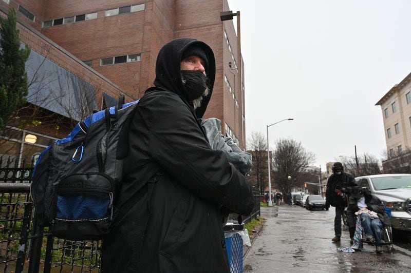 January 20, 2022 Atlanta - Michael Cumbie holding all his belongings stands in rain outside the Gateway Center in Atlanta on Thursday, January 20, 2022. The Gateway Center is a homeless service center. (Hyosub Shin / Hyosub.Shin@ajc.com)