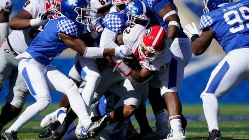 Georgia running back Kendall Milton (22) is tackled by several Kentucky defenders during the second half Oct. 31, 2020, in Lexington, Ky. The Bulldogs won 14-3. (Bryan Woolston/AP)