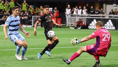 022722 : Atlanta United attacker Luiz De Araujo scores a goal past Sporting KC goalkeeper Tim Melia to take a 1-0 lead but was injured on the play and had to come out in a MLS soccer match on Sunday, Feb. 27, 2022, in Atlanta.  “Curtis Compton / Curtis.Compton@ajc.com”`