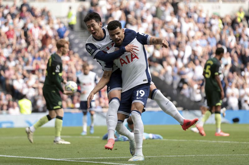 Tottenham Hotspur's Dominic Solanke, center, celebrates scoring his side's first goal of the game with teammate Son Heung-Min, during the English Premier League soccer match between Tottenham Hotspur and Brentford, at the Tottenham Hotspur Stadium, in London, Saturday, Sept. 21, 2024. (Steven Paston/PA via AP)