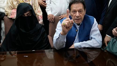 FILE - Pakistan's former Prime Minister Imran Khan, right, and Bushra Bibi, his wife, speak to the media before signing documents to submit surety bond over his bails in different cases, at an office of Lahore High Court in Lahore, Pakistan, on July 17, 2023. An appeals court in Pakistan Thursday, June 27, 2024 upheld the conviction and seven-year prison sentence of former Prime Minister Imran Khan and his wife for their 2018 marriage which was found to be unlawful, officials said. (AP Photo/K.M. Chaudary, File)