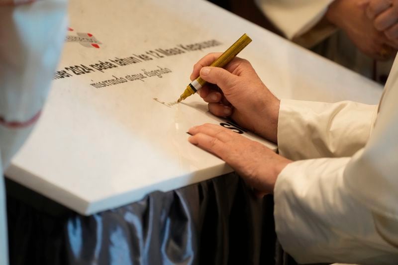 Pope Francis signs a marble plaque as he leaves the Indonesian Episcopal Conference headquarters where he met with a group of sick people, people with disabilities and the poor, assisted by various charitable organizations linked to the Indonesian Episcopal Conference, in Jakarta, Thursday, Sept. 5, 2024. (AP Photo/Gregorio Borgia)