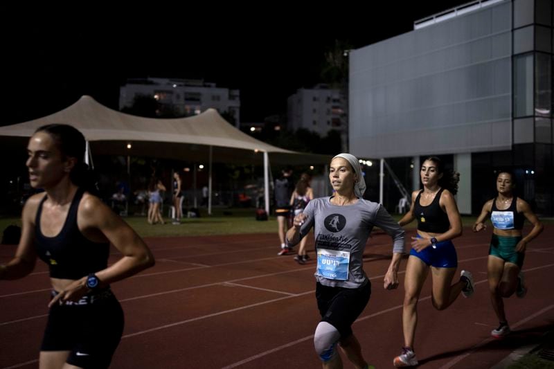 Beatie Deutsch, an Orthodox Jewish runner, center, trains with her team in Tel Aviv, Israel, Wednesday, June 26, 2024. (AP Photo/Maya Alleruzzo)