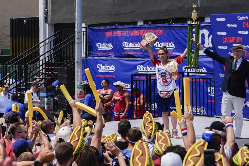 Miki Sudo, second from right, reacts after winning the women's division in Nathan's Famous Fourth of July hot dog eating contest, Thursday, July 4, 2024, at Coney Island in the Brooklyn borough of New York. Sudo ate a record 51 hot dogs. (AP Photo/Julia Nikhinson)