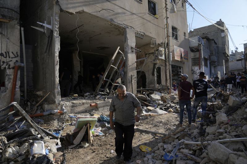 Palestinians examine the damage following an Israeli airstrike in the West Bank city of Tulkarem, which Palestinian health officials say killed 18 people and the Israeli military says took out a Hamas leader, on Friday, Oct. 4, 2024. (AP Photo/Nasser Nasser)