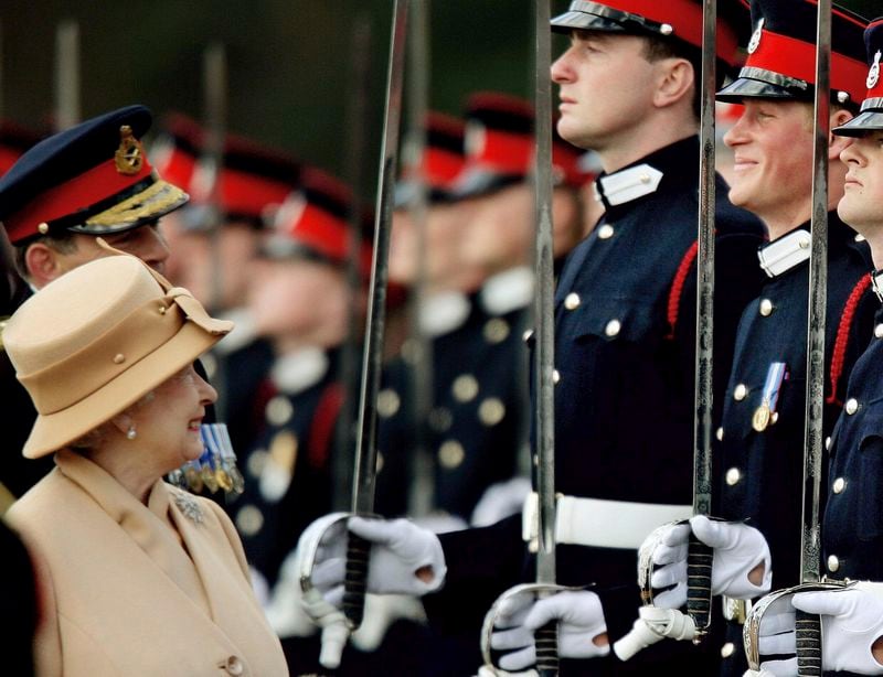 FILE - Britain's Prince Harry, second from right, grins as his grandmother Queen Elizabeth II smiles, as she inspects the Sovereign's Parade at the Royal Military Academy in Sandhurst, England, Wednesday, April 12, 2006. (AP Photo/Dylan Martinez, pool, File)