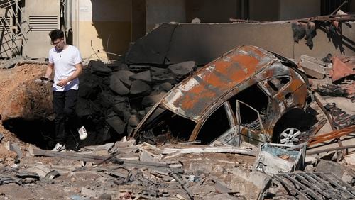 A man walks on rubble at the site of an Israeli airstrike in Beirut's southern suburbs, Sunday, Sept. 29, 2024. (AP Photo/Hassan Ammar)