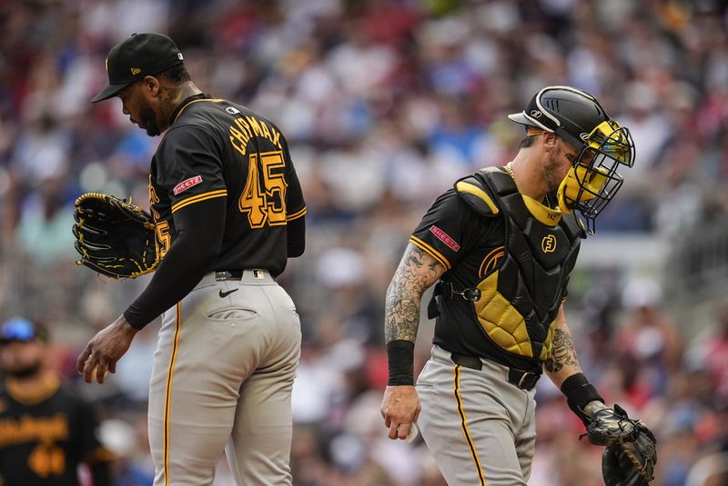 Pittsburgh Pirates catcher Yasmani Grandal (6) leaves the mound after speaking with Aroldis Chapman (45) in the nineth inning of a baseball game against the Atlanta Braves, Saturday, June 29, 2024, in Atlanta. (AP Photo/Mike Stewart)