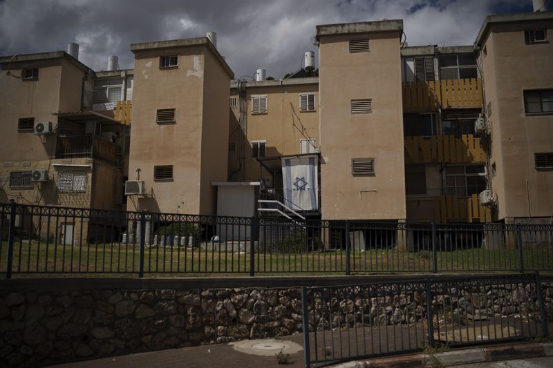 A Israeli flag hangs on a balcony of a residential building in Kiryat Shmona, a city located next to the border with Lebanon, northern Israel, Tuesday, Sept. 17, 2024. (AP Photo/Leo Correa)