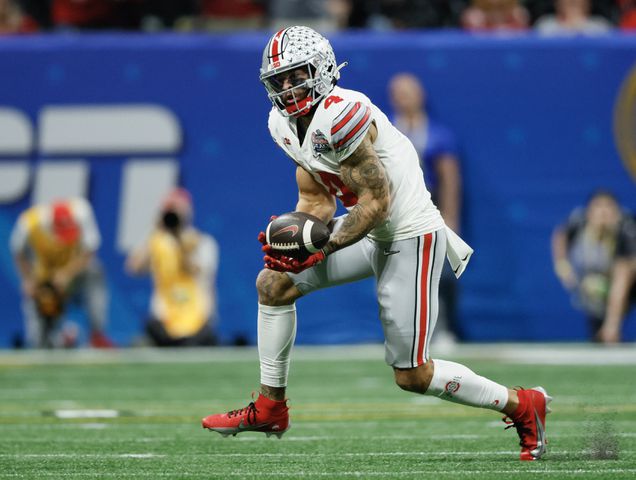 Ohio State Buckeyes wide receiver Julian Fleming (4) catches a 25 yard pass during the third quarter the College Football Playoff Semifinal between the Georgia Bulldogs and the Ohio State Buckeyes at the Chick-fil-A Peach Bowl In Atlanta on Saturday, Dec. 31, 2022. (Jason Getz / Jason.Getz@ajc.com)