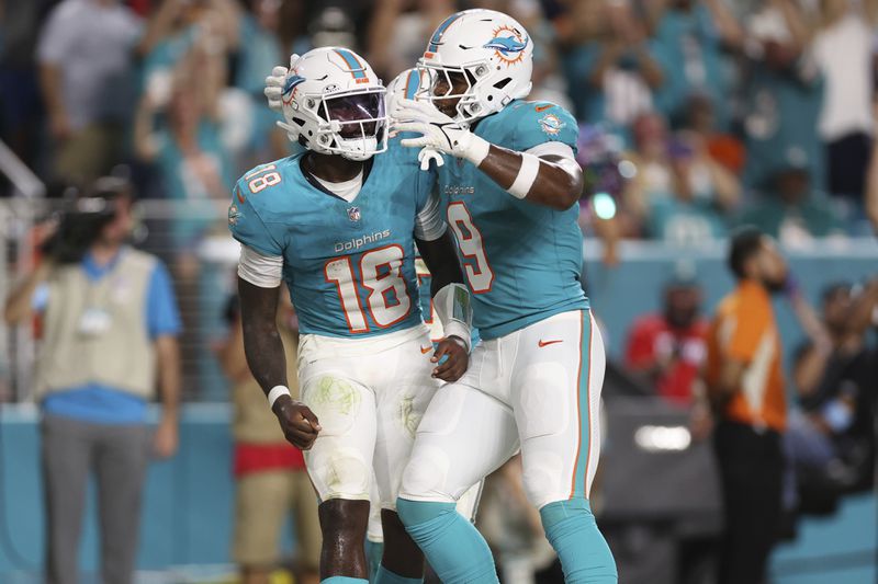 Miami Dolphins quarterback Tyler Huntley (18) celebrates his touchdown with tight end Jonnu Smith (9) during the second half of an NFL football game against the Tennessee Titans, Monday, Sept. 30, 2024, in Miami Gardens, Fla. (AP Photo/Brennan Asplen)