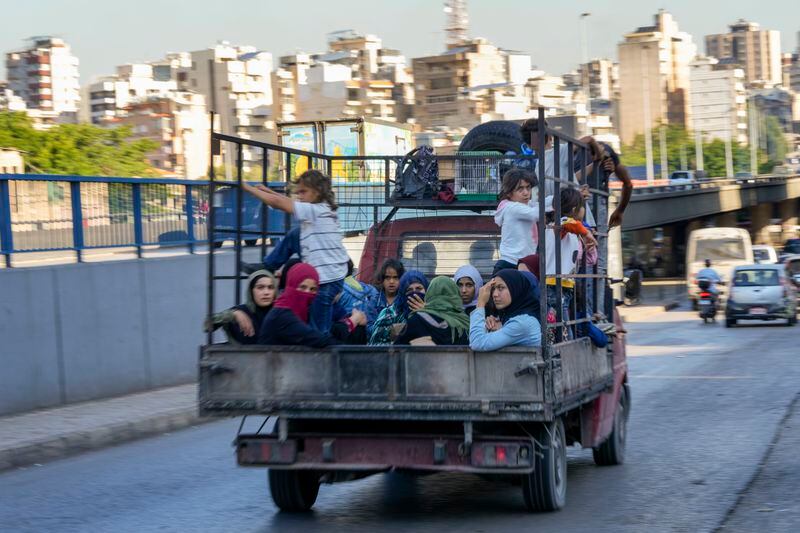 Lebanese citizens who fled from the southern villages amid ongoing Israeli airstrikes Monday, sit in a pickup in Beirut, Tuesday, Sept. 24, 2024. (AP Photo/Hassan Ammar)