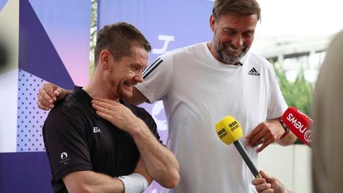 German football manager Jurgen Klopp, right, and para badminton player Wojtek Czyz react as they discuss the results of Czyz's match in Porte La Chapelle Arena during the Paralympic Games on Wednesday, Aug. 28, 2024, in Paris. (AP Photo/Samantha Hurley).