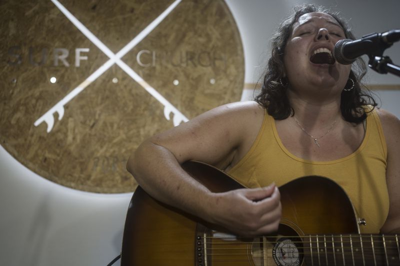 Surf Church member Annalise Hunnicut sings during a worship service at the church in Porto, Portugal on Sunday, Aug. 18, 2024. (AP Photo/Luis Andres Henao)