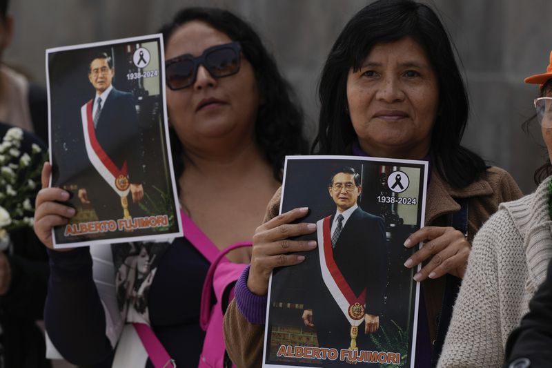 Supporters of former President Alberto Fujimori line up to pay their respects outside a museum where his body is lying in Lima, Peru, Thursday, Sept. 12, 2024. (AP Photo/Guadalupe Pardo)