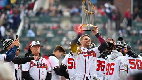 Freddie Freeman hoists the 2021 World Series trophy for fans on Nov. 5. (Daniel Varnado/ For The Atlanta Journal-Constitution)