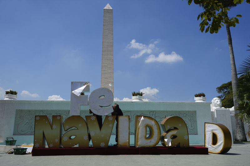 People set up Christmas decorations in Caracas, Venezuela, Tuesday, Oct. 1, 2024. (AP Photo/Ariana Cubillos)