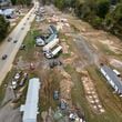 Homes and vehicles that were damaged in a flash flood from Hurricane Helene lie on the side of a road near the Swannanoa River, Tuesday, Oct. 1, 2024, in Swannanoa, N.C. (AP Photo/Mike Stewart)