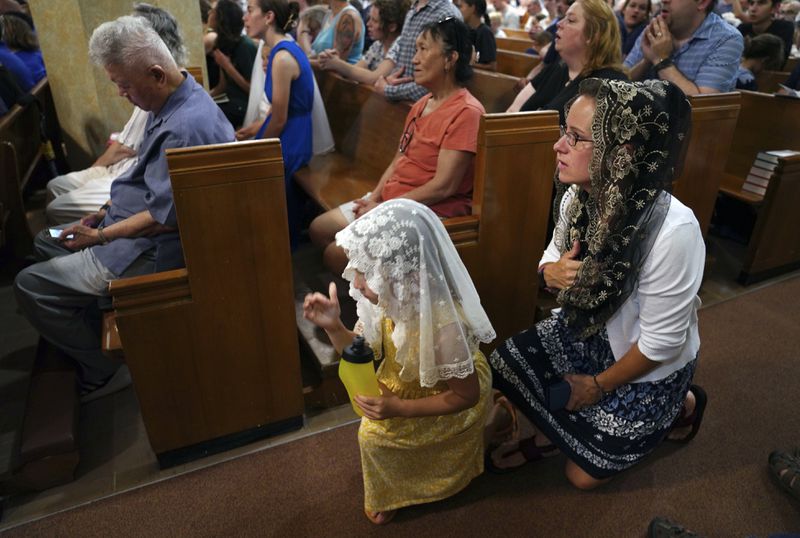Families attend a prayer service as a part of the National Eucharistic Pilgrimage at St. Peter Church in Steubenville, Ohio, Friday, June 21, 2024. The service was part of the National Eucharistic Pilgrimage, which seeks to raise devotion around a sacrament in which Catholics believe they encounter Jesus' real presence. (AP Photo/Jessie Wardarski)