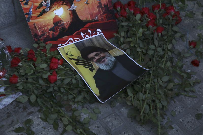 A poster of Hezbollah leader Sayyed Hassan Nasrallah is placed on flowers in front of the Lebanese Embassy in Tehran, Iran, Wednesday, Sept. 18, 2024. (AP Photo/Vahid Salemi)