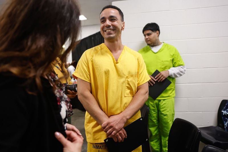 Daniel Matos smiles as he chats with an instructor after receiving his GED during a graduation ceremony for inmates at Cobb County Detention Facility in Marietta on Tuesday, May 28, 2024. (Natrice Miller/ AJC)