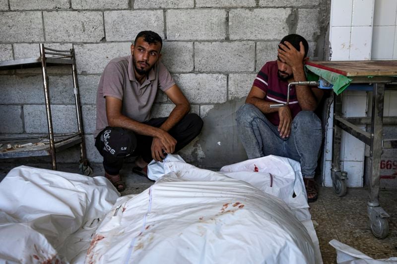 Palestinians mourn relatives killed in the Israeli bombardment of the Gaza Strip, at a hospital in Deir al-Balah, Thursday, Aug. 22, 2024. (AP Photo/Abdel Kareem Hana)