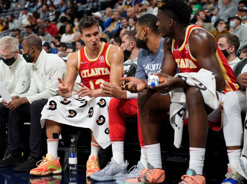 Atlanta Hawks guard Bogdan Bogdanovic, left, confers with center Clint Capela, right, the first half of the team's NBA basketball game against the Denver Nuggets on Friday, Nov. 12, 2021, in Denver. (AP Photo/David Zalubowski)