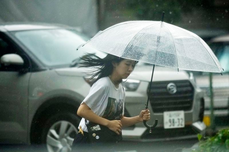 A person walks in the rain Friday, Aug. 30, 2024, in Tokyo, as a severe weather system has affected. (AP Photo/Eugene Hoshiko)