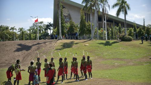 FILE - Performers in traditional dresses stand outside of Parliament Haus in Port Moresby, Papua New Guinea, on Nov. 16, 2018. At least 26 people has been reported killed by a gang of men in three remote villages last week in Papua New Guinea's north, United Nations and police officials said on Wednesday, July 24, 2024. (AP Photo/Mark Schiefelbein, FILE)