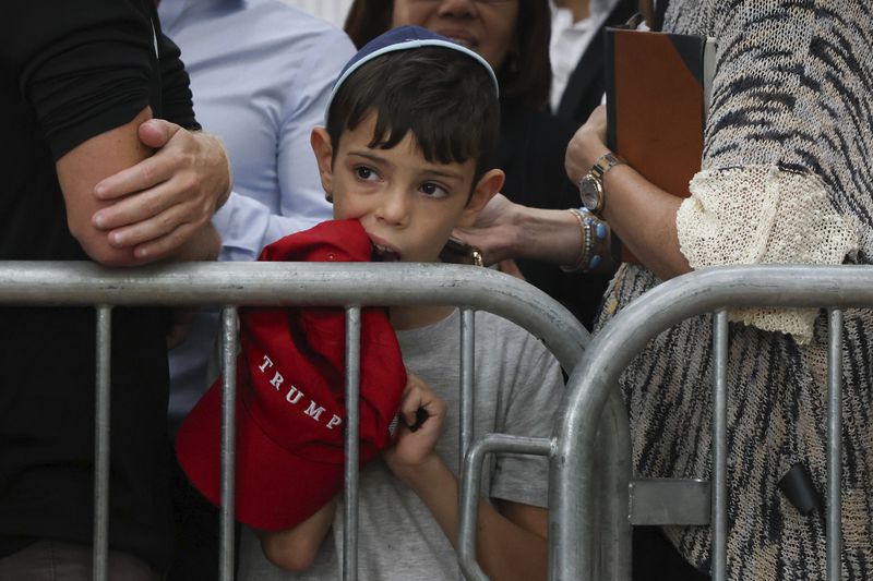 A boy awaits the arrival of Republican presidential nominee former President Donald Trump at Ohel Chabad-Lubavitch, Monday, Oct. 7, 2024, in New York. (AP Photo/Yuki Iwamura)