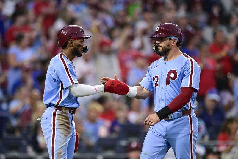 Philadelphia Phillies' Johan Rojas, left, and Kyle Schwarber high-five after scoring on a double hit by Trea Turner off Washington Nationals' Mitchell Parker during the fourth inning of a baseball game, Thursday, Aug. 15, 2024, in Philadelphia. (AP Photo/Derik Hamilton)