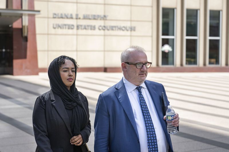 Ladan Mohamed Ali, left, a Seattle woman who attempted to bribe a Minnesota juror with a bag of $120,000 in cash in exchange for an acquittal in one of the country's largest COVID-19-related fraud cases, and her attorney, Eric Newmark, leave the Diana E. Murphy U.S. Courthouse, Thursday, Sept. 5, 2024, in Minneapolis, following after a hearing where she plead guilty. (Alex Kormann/Star Tribune via AP)