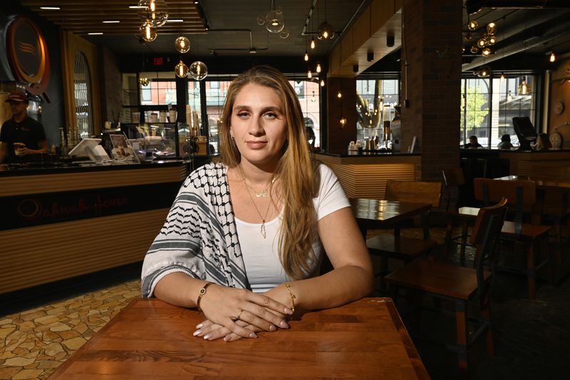 Layla Elabed, co-director of the Uncommitted National Movement, sits at a table, Friday, Aug. 30, 2024, in Dearborn, Mich. (AP Photo/Jose Juarez)