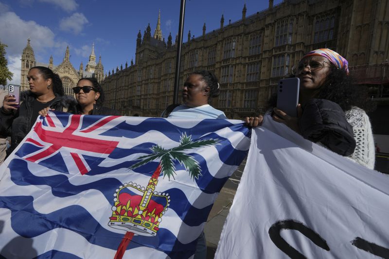 Mary Marjorie Sophie, center, and other Chagossians attend a protest to respond to the U.K. announcement agreeing to hand sovereignty of the long-contested Chagos Islands to Mauritius and against their "Exclusion" from Chagos negotiations, outside the House of Parliament, in London, Monday, Oct. 7, 2024. (AP Photo/Kin Cheung)