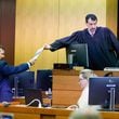 Baxter Drennon (left), a lawyer representing the Republican National Committee, hands documents to Fulton County Superior Court Judge Robert McBurney on Tuesday during a trial brought by the Georgia Democratic Party challenging the State Election Board’s certification rule. (Miguel Martinez/AJC)