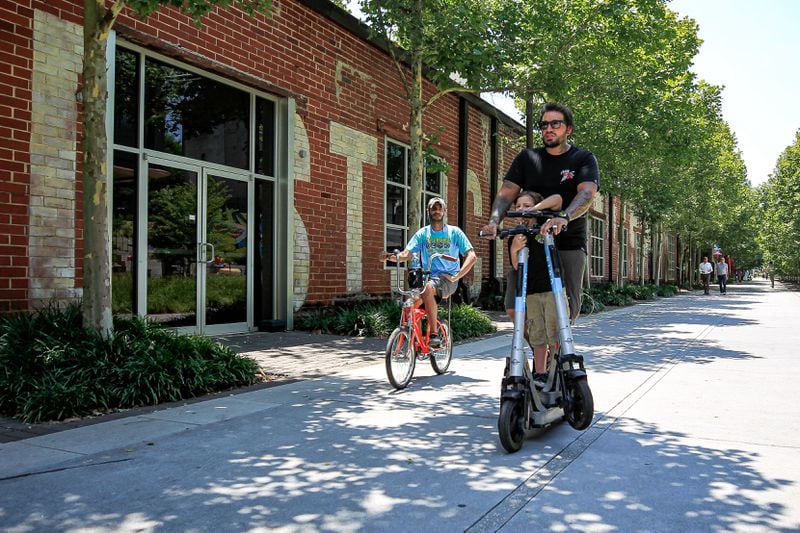 People in scooter and bike ride across a trail by Krog Street Market in Atlanta, Georgia on Thursday, June 13, 2024.   (Ziyu Julian Zhu / AJC)