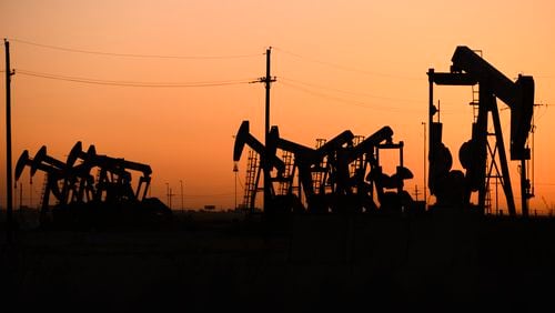 FILE - An array of pumpjacks operate near the site of a new oil and gas well being drilled April 8, 2022 in Midland, Texas. (Eli Hartman/Odessa American via AP, File)