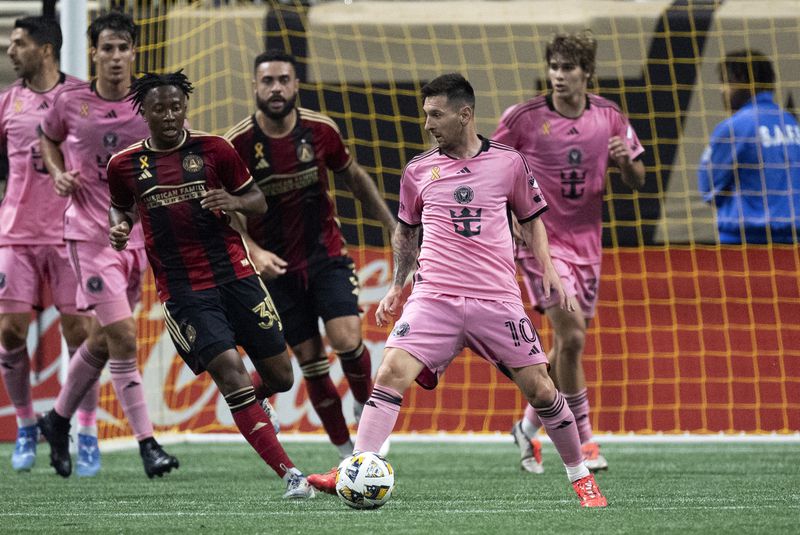 Inter Miami forward Lionel Messi (10) works in front of Atlanta United midfielder Ajani Fortune (35) during the second half of a MLS soccer match Wednesday, Sept. 18, 2024. (AP Photo/John Bazemore)