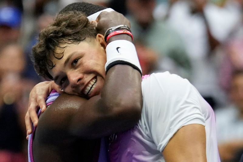 Frances Tiafoe, of the United States, left, hugs Ben Shelton, of the United States, at the net after winning their third round match of the U.S. Open tennis championships, Friday, Aug. 30, 2024, in New York. (AP Photo/Seth Wenig)