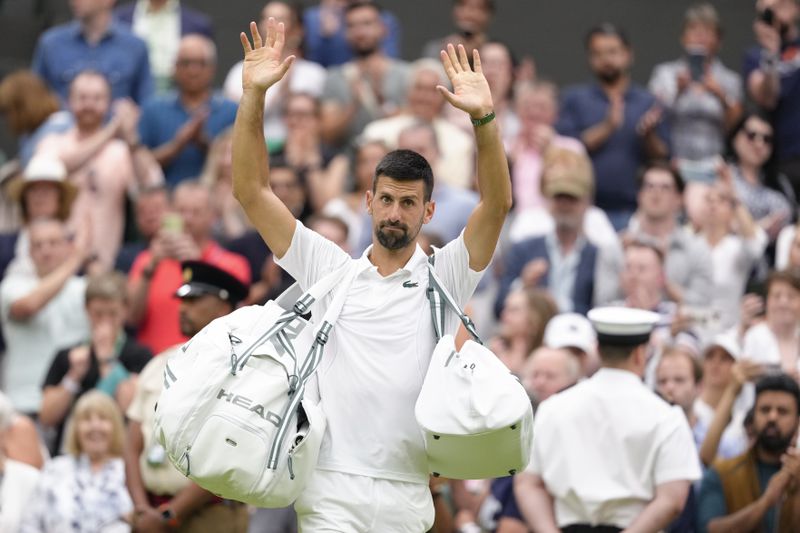 Serbia's Novak Djokovic waves after defeating Vit Kopriva of the Czech Republic in their first round match at the Wimbledon tennis championships in London, Tuesday, July 2, 2024. (AP Photo/Kirsty Wigglesworth)