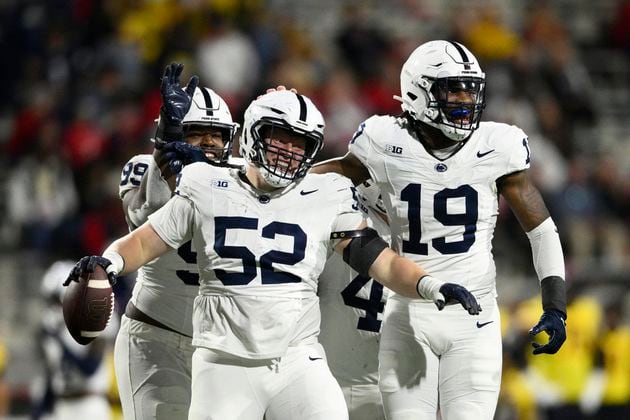 Penn State defensive tackle Jordan van den Berg (52) celebrates with defensive end Jameial Lyons (19) and defensive tackle Coziah Izzard (99) after recovering a fumble by Maryland during the second half of an NCAA college football game, Saturday, Nov. 4, 2023, in College Park, Md. (AP Photo/Nick Wass)