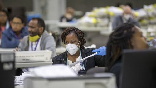 A Fulton County employee prepares mail-in paper ballots to be counted at the Georgia World Congress Center during the Georgia primary elections on Tuesday. (ALYSSA POINTER / ALYSSA.POINTER@AJC.COM)