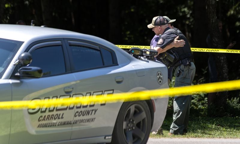 Law enforcement officers embrace at the scene where a Carroll County deputy was shot.