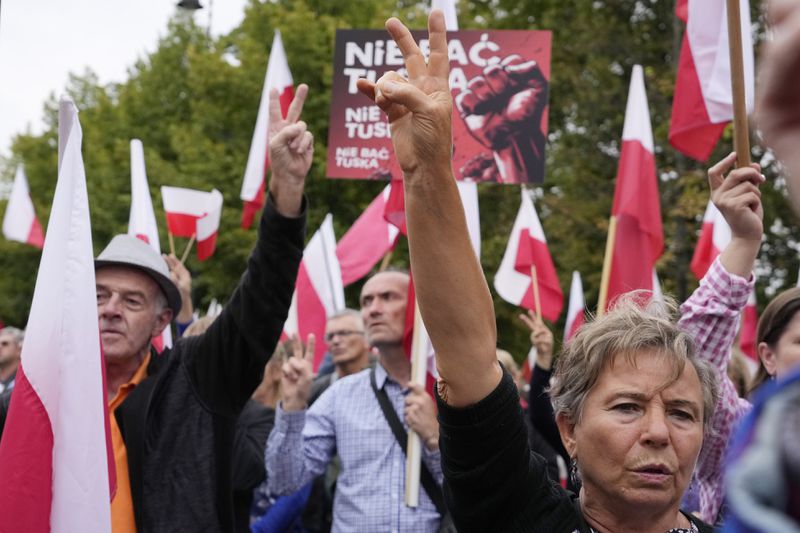 Backers of the right-wing opposition party Law and Justice take part in a protest ally of a few thousand people against the policies of Prime Minister Donald Tusk's Cabinet before the Ministry of Justice, in Warsaw, Poland, Saturday Sept. 14, 2024. (AP Photo/Czarek Sokolowski)