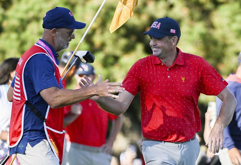 United States team member Keegan Bradley, right, celebrates with caddie Scott Vail, left, following his win over International team member Si Woo Kim, of South Korea, in their fifth-round singles match at the Presidents Cup at the Royal Montreal Golf Club in Montreal, Sunday, Sept. 29, 2024. (Graham Hughes/The Canadian Press via AP)