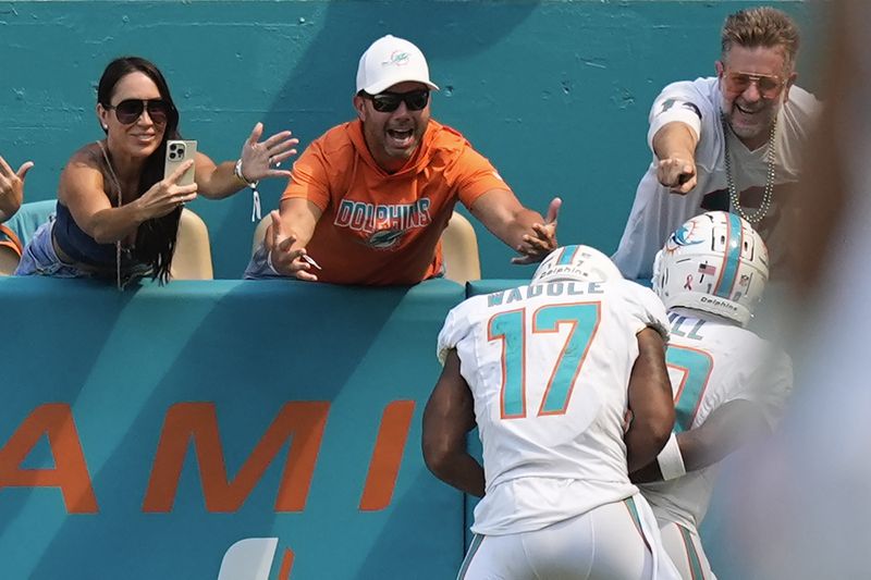 Miami Dolphins wide receiver Jaylen Waddle (17) pretends to put wide receiver Tyreek Hill (10) in handcuffs as they celebrate Hill's touchdown during the second half of an NFL football game against the Jacksonville Jaguars, Sunday, Sept. 8, 2024, in Miami Gardens, Fla. (AP Photo/Rebecca Blackwell)