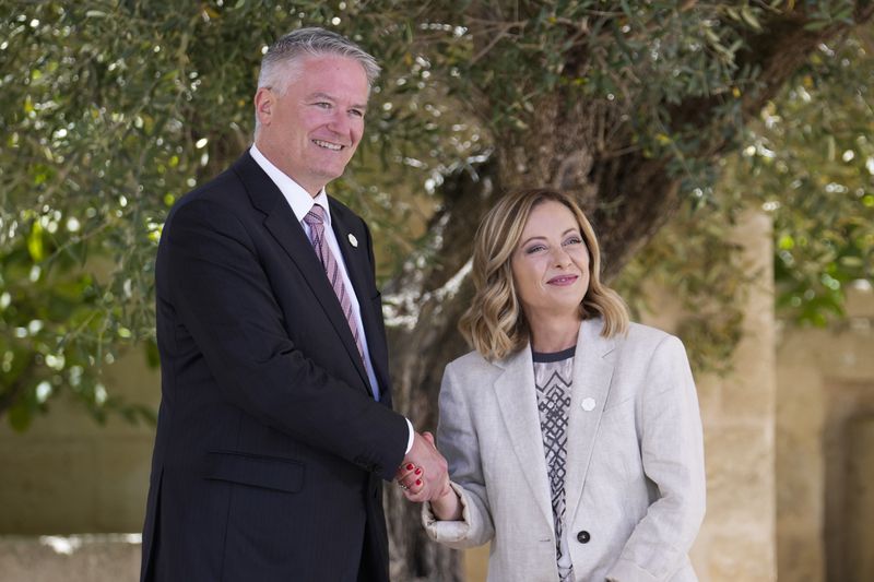 Secretary-General of the Organisation for Economic Co-operation and Development Mathias Cormann, left, is welcomed by Italian Prime Minister Giorgia Meloni at the G7 in Borgo Egnazia, near Bari in southern Italy, Friday, June 14, 2024. (AP Photo/Luca Bruno)